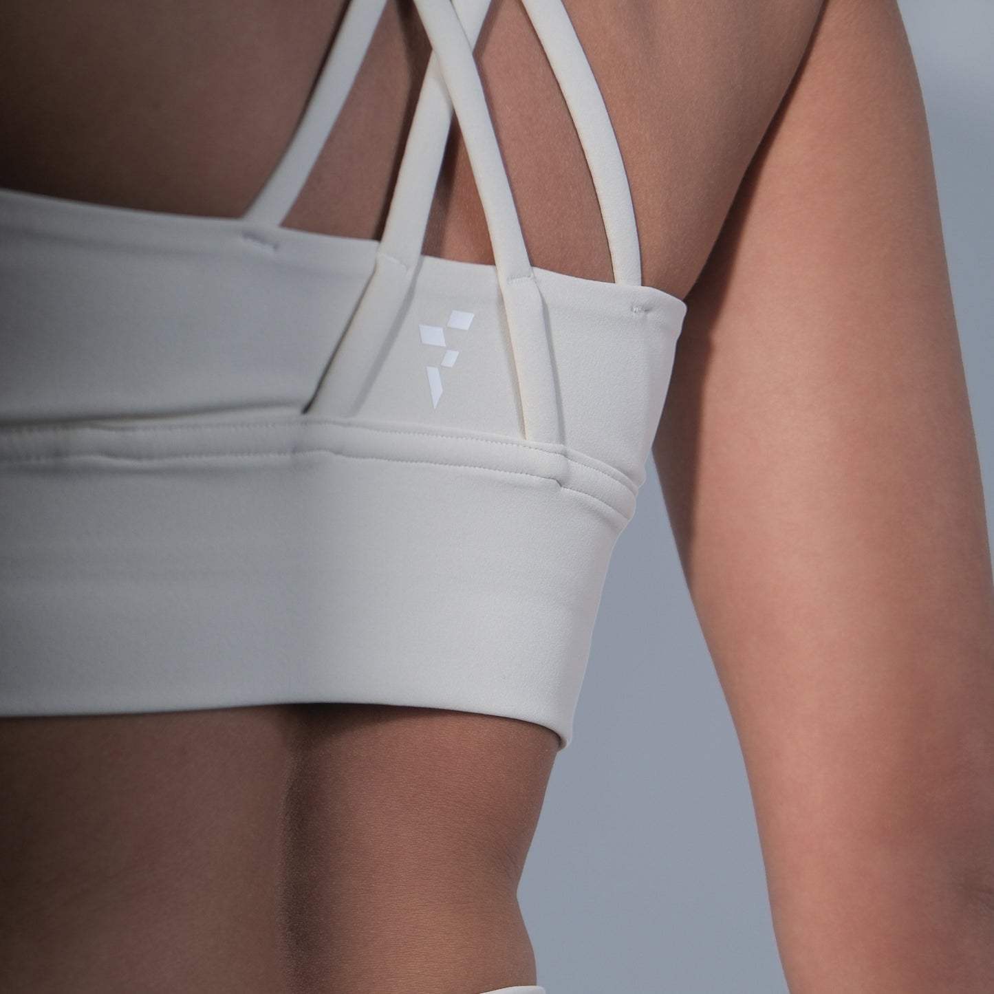 White sports bra and leggings on a neutral background