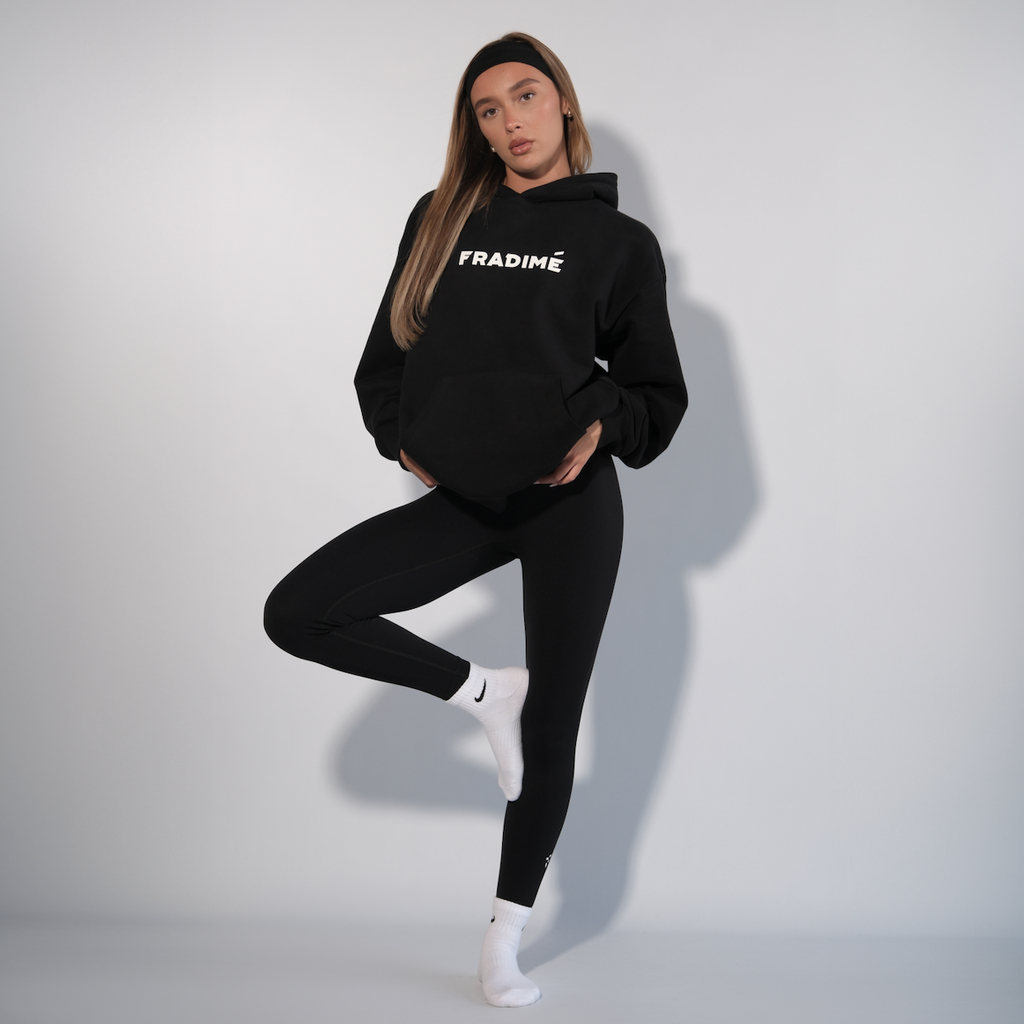Person wearing a black hoodie with 'FRAIDMÉ' branding on a white background